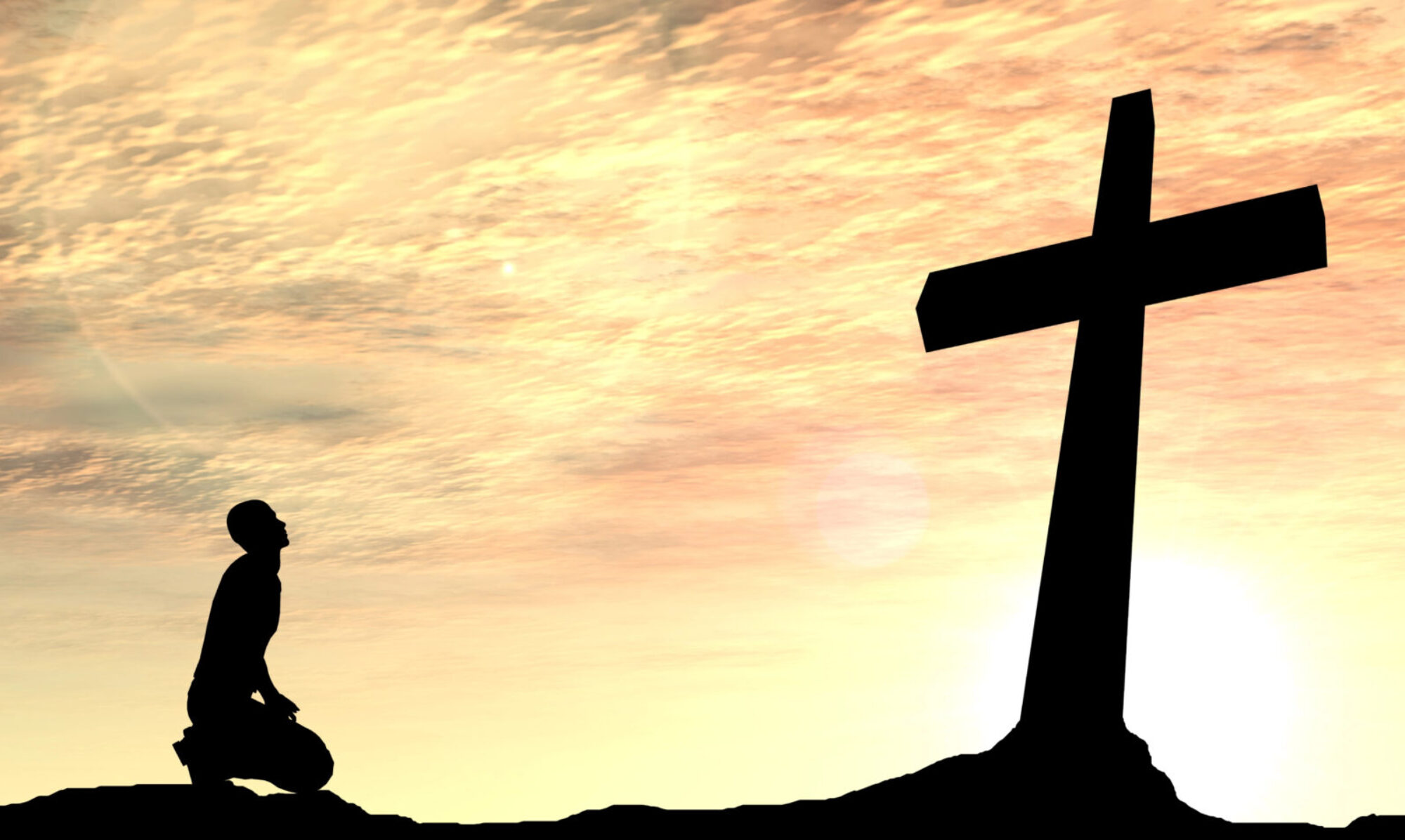 silhouette of a man bowing before a cross